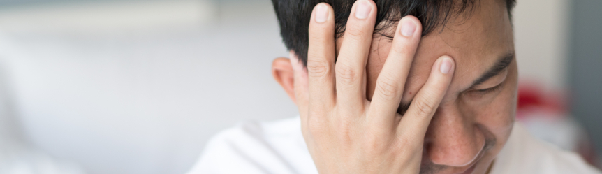 Man holding his front head, experience migraine